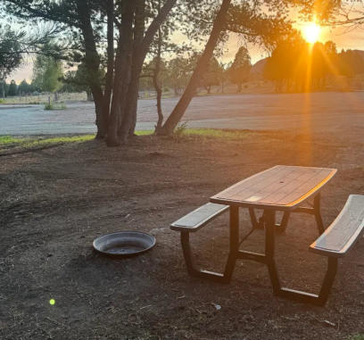 A picnic table and fire ring at a rv site at sunset at Soda Creek Campground in Soda Springs, Idaho.